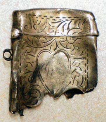 A locket or metal case which apparantely saved him from much more serious injury or even maybe saved his life when he was hit (in the bottom) by shrapnel again, so I am told. It is a Victorian Silver Vesta case, for keeping matches dry.